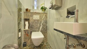 Ein Badezimmer mit Toilette, Waschbecken und Marmorböden.