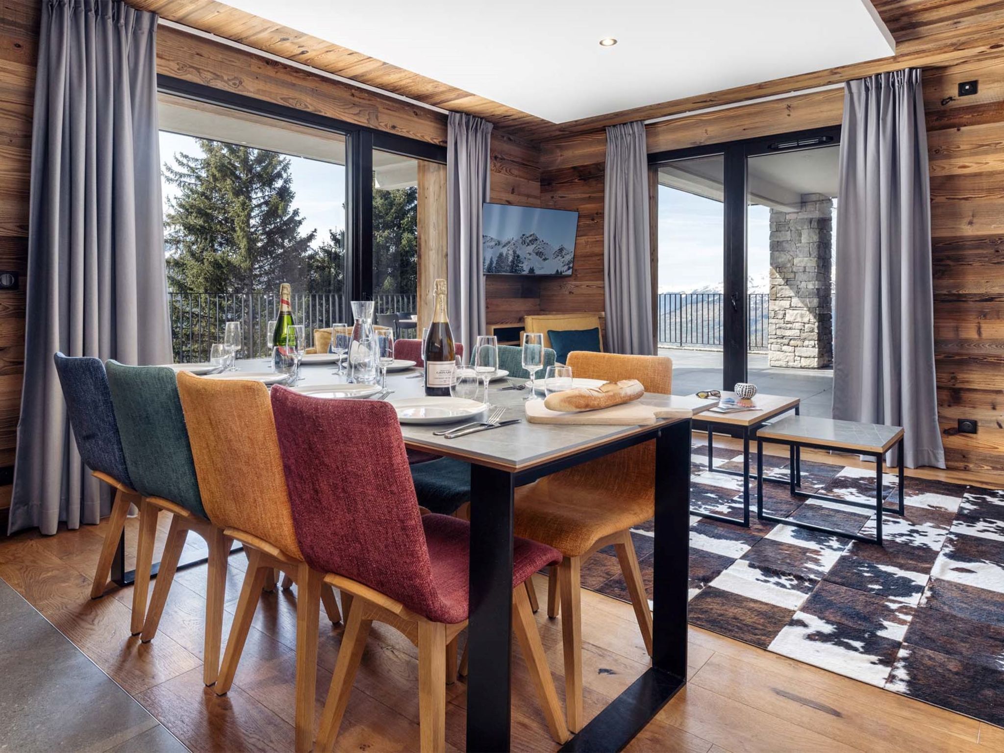 Un espace repas moderne avec une table en bois, des chaises et une vue sur l’extérieur.