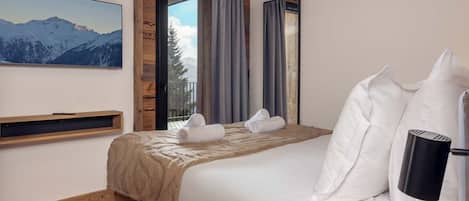 Une chambre à coucher avec un lit, un plafond en bois, une fenêtre avec des rideaux, un tableau accroché au mur et une table de chevet.