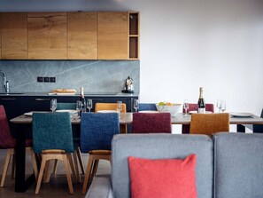 A modern dining area with wooden cabinets, a marble countertop, and a variety of chairs. - Résidence l'Orée du Bois by Interhome (La Rosière)