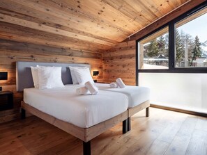 Ein Schlafzimmer mit Holzwandverkleidung, einem großen Fenster, einem Bett und einem Nachttisch.