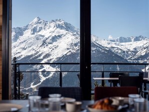 A dining area with a view of snow-covered mountains. - Résidence l'Orée du Bois by Interhome (La Rosière)