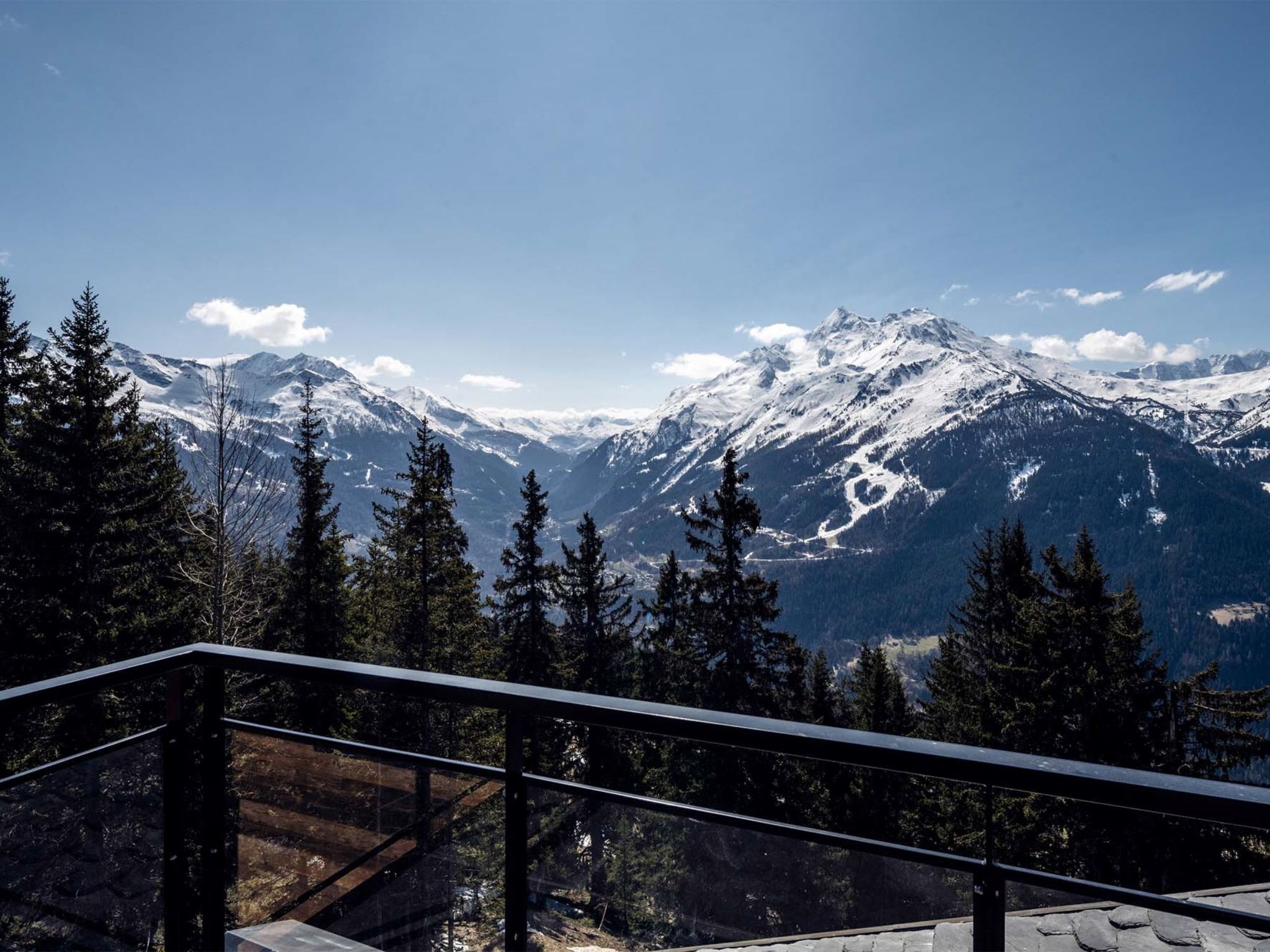 A mountain landscape with snow-covered peaks and a clear sky.