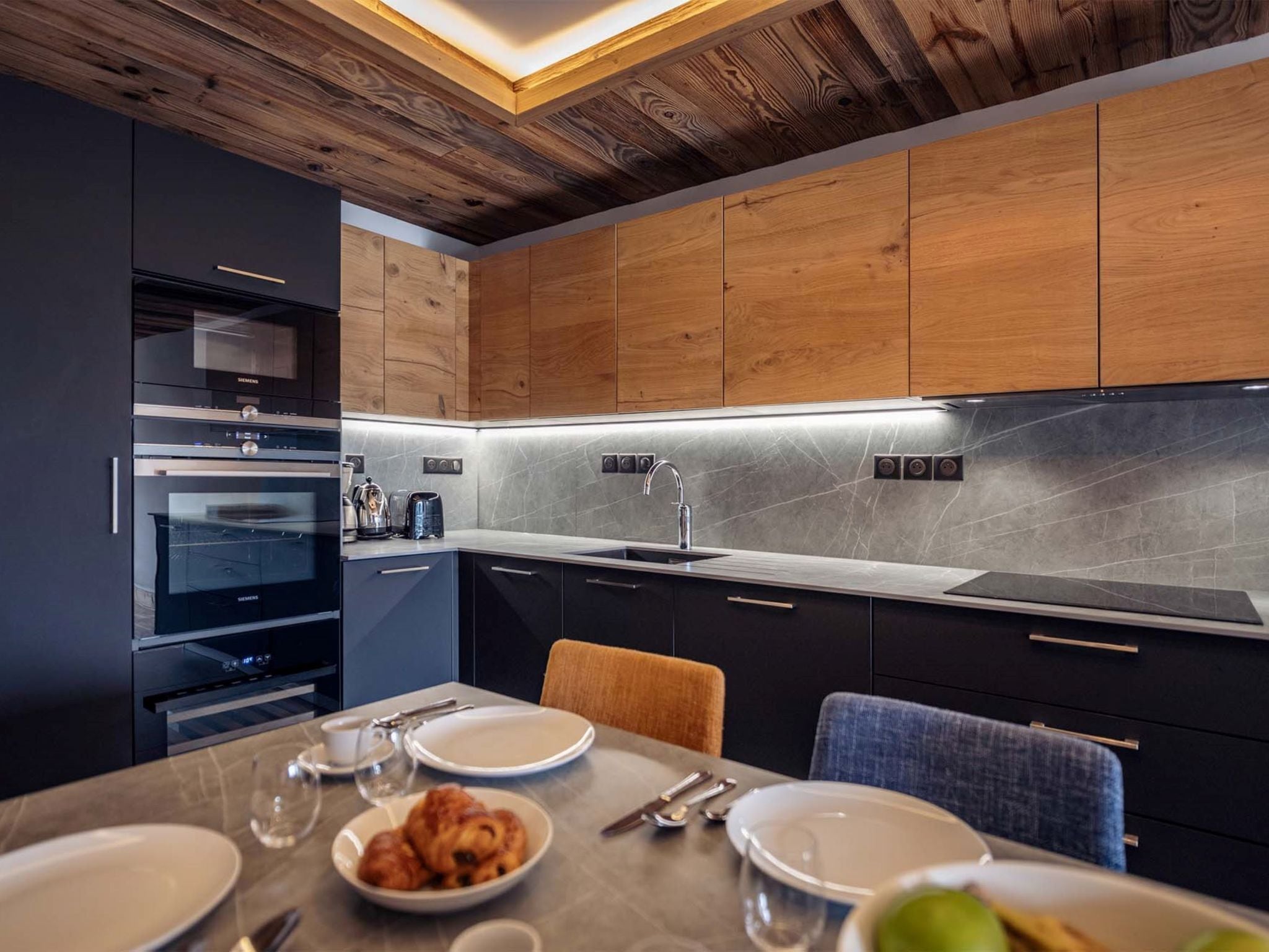 Una cocina moderna con armarios de madera, horno empotrado y encimera elegante.