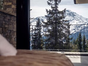 A room with a view of snow-covered mountains and pine trees. - Résidence l'Orée du Bois by Interhome (La Rosière)