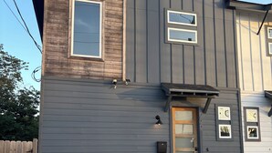 A two-story building with a wooden upper section and a grey lower section. - Newly Built Home 7 Min Drive River Walk & Downtown - 1222 (San Antonio)