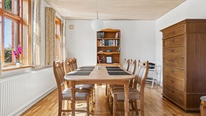 A dining room with a wooden table and chairs, a bookshelf, and a cabinet. - "Helge" - 10km from the sea by Interhome (Rønne)