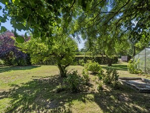 A garden with a large tree, a greenhouse, and a wooden fence. - "Helge" - 10km from the sea by Interhome (Rønne)