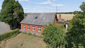 A red brick house with a tiled roof, surrounded by greenery and a field. - "Helge" - 10km from the sea by Interhome (Rønne)