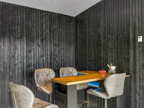 Un comedor moderno con una mesa de madera y cuatro sillas tapizadas.