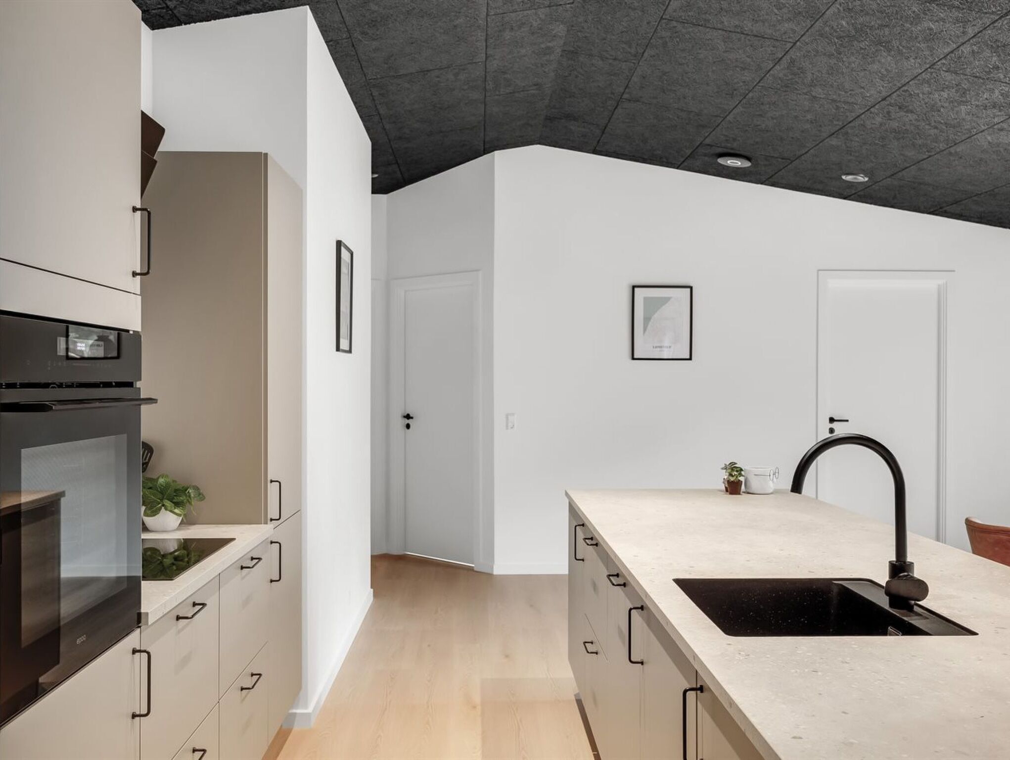 Una cocina moderna con horno integrado, un lavamanos y una encimera.