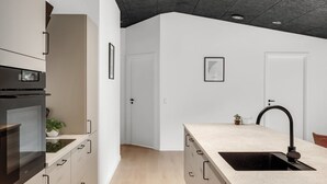 Eine moderne Küche mit Einbauofen, Spüle und Arbeitsplatte.