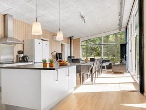 A modern kitchen with a central island, white cabinetry, and pendant lighting. - "Nakke" - 900m from the sea by Interhome (Hadsund)