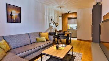 A modern living room with a sofa, coffee table, and dining area.