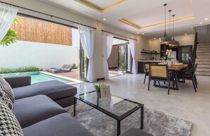 A modern living room with a pool, dining area, and kitchen. - Villa Azura Seminyak (Badung)