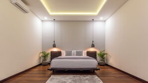 A modern bedroom with a bed, bedside lamps, and a rug. - Villa Azura Seminyak (Badung)