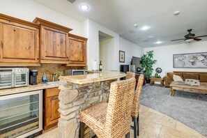A kitchen with wooden cabinets, a stone accent wall, a built-in oven, and a stone countertop. - 3 Mi to Dtwn Gilbert! Apt w/ Shared Poolside Oasis (Gilbert)