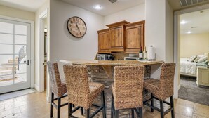 A kitchen with a round island, wooden cabinets, and a wall clock. - 3 Mi to Dtwn Gilbert! Apt w/ Shared Poolside Oasis (Gilbert)