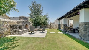 A patio area with stone walls, outdoor seating, and a grassy lawn. - Santa Teresa Retreat w/ Outdoor Fireplace (Santa Teresa)