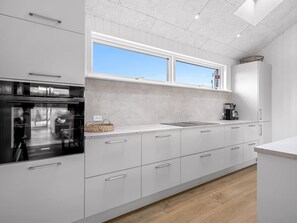 A modern kitchen with white cabinetry, a large window, and a visible Siemens appliance. - "Tayara" - 900m from the sea by Interhome (Glesborg)