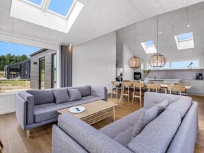 A spacious living area with a grey sofa set, a wooden coffee table, and a dining area with a wooden table and chairs. - "Tayara" - 900m from the sea by Interhome (Glesborg)