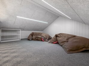 A room with a sloped ceiling, white walls, and a grey carpet. There are two large bean bags with red tags. - "Tayara" - 900m from the sea by Interhome (Glesborg)