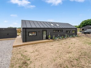 A modern two-story building with a dark exterior, a flat roof, and a small deck area. - "Tayara" - 900m from the sea by Interhome (Glesborg)