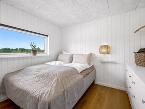 A bedroom with a bed, a window, a wall-mounted lamp, and a view of greenery outside. - "Tayara" - 900m from the sea by Interhome (Glesborg)