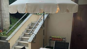 Un espace patio avec une table recouverte d’une nappe, un escalier et une porte.