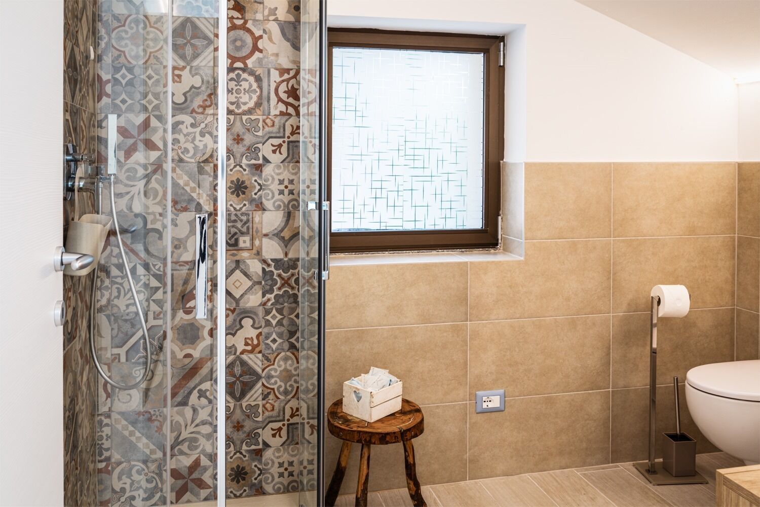 Un baño con ducha, inodoro y ventana.