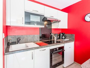 A kitchen with white cabinets, a microwave, a coffee maker, and a Bosch oven. - Annabel by Interhome (Houlgate)