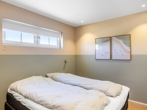 A bedroom with a bed, a window, and two wall-mounted artworks. - "Indra" - 800m from the sea by Interhome (Løkken)