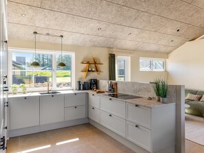 A modern kitchen with a large island, built-in cabinets, and a view of the outdoors. - "Indra" - 800m from the sea by Interhome (Løkken)