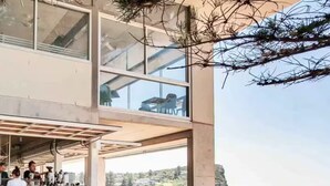 Un espace extérieur aménagé avec des tables et des chaises, un bar et une vue sur la mer.