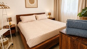 A neatly arranged bedroom with a wooden bed, a ceiling fan, an air conditioning unit, a bedside lamp, a framed artwork, and a window with curtains. - Laguna Beach 405- 300m from Dominicus Public Beach (Dominicus)