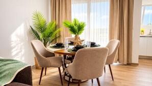 A dining area with a round table, four chairs, and potted plants. - Laguna Beach 405- 300m from Dominicus Public Beach (Dominicus)