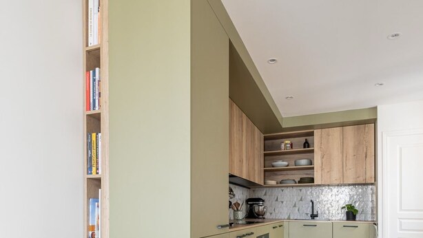 A modern kitchen with wooden cabinets, a built-in oven, and a countertop with a coffee maker. - Stunning Designer Apartment in the Heart of Paris (11th Arrondissement) (Paris)