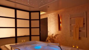 Une salle de spa équipée d’une grande baignoire, d’un miroir mural et d’un porte-serviettes.