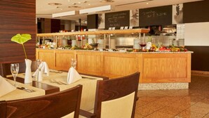 Un restaurant avec un comptoir en bois, une vitrine réfrigérée et un menu écrit à la craie sur un tableau noir.