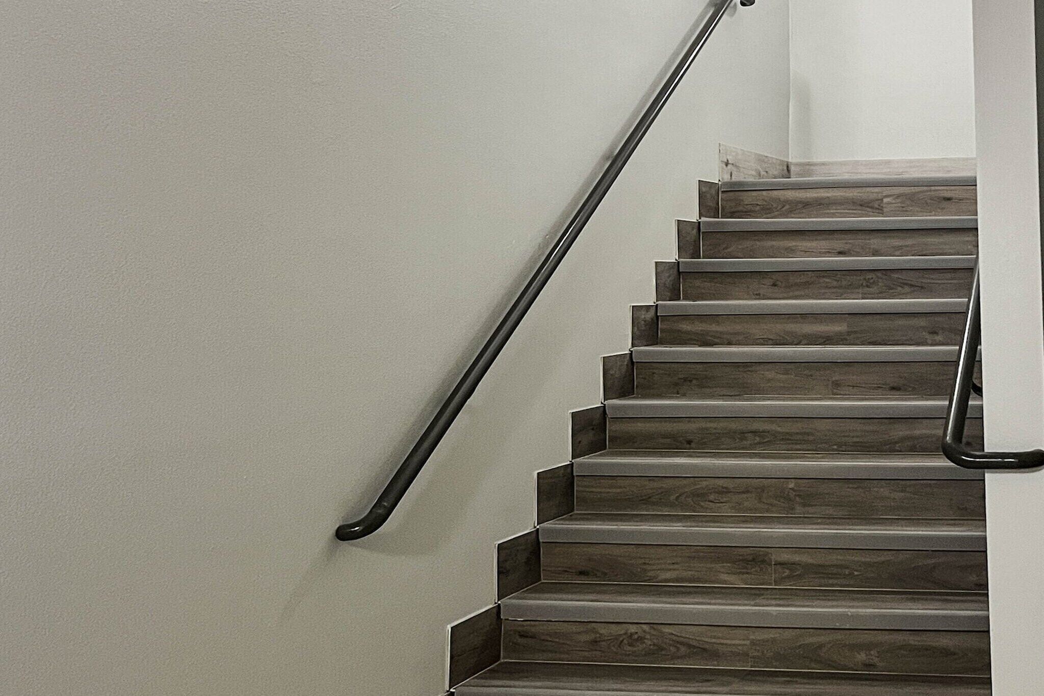 Una escalera de madera con barandilla de metal.