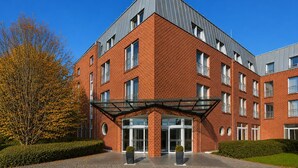 A multi-story brick building with a modern design, featuring a glass entrance and a clear sky. - Sunday Hotel Köln Hürth Disability Access (Hürth)