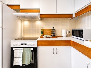 Una cocina moderna con estufa, microondas y armarios.