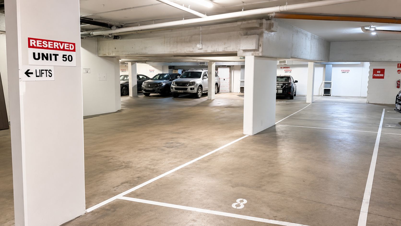 Un parking à plusieurs niveaux doté d’une signalisation claire indiquant les places réservées et les zones où le stationnement est interdit.