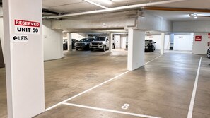 A multi-level parking garage with clear signage indicating reserved units and no parking zones. - Robin's Oceanview Penthouse | 1 Min to Beach (Surfers Paradise)