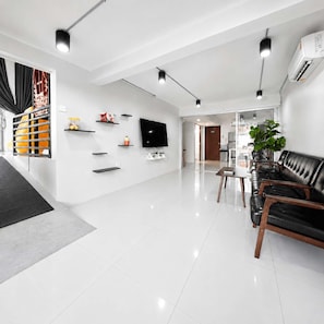 A modern living room with a flat-screen TV, black leather sofa, and a dining area with a table and chairs. - 3-Bedroom Private Pool Villa for Up to 10 Guests (Si Racha)
