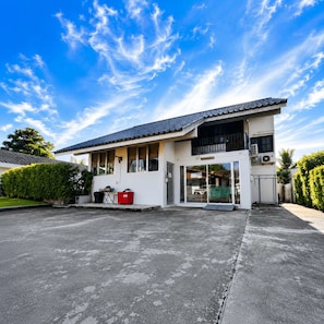 A two-story building with a flat roof, large windows, and an air conditioning unit on the exterior wall. - 3-Bedroom Private Pool Villa for Up to 10 Guests (Si Racha)