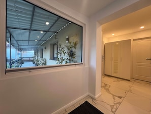 A corridor with a large window, a door, and a tiled floor. - House by the Park in Dreieich (Dreieich)