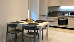 Eine moderne Küche mit Esstisch und Stühlen, einer Mikrowelle und einer Kaffeemaschine.