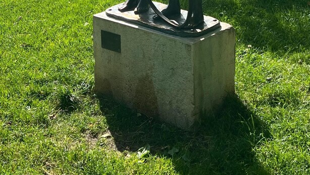 Estatua de un hombre y un niño en un parque.