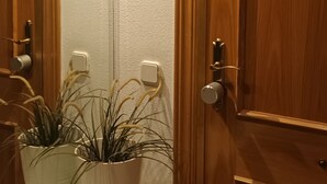 Un bagno con porte in legno, un piano di lavoro in marmo e due piante in vaso.